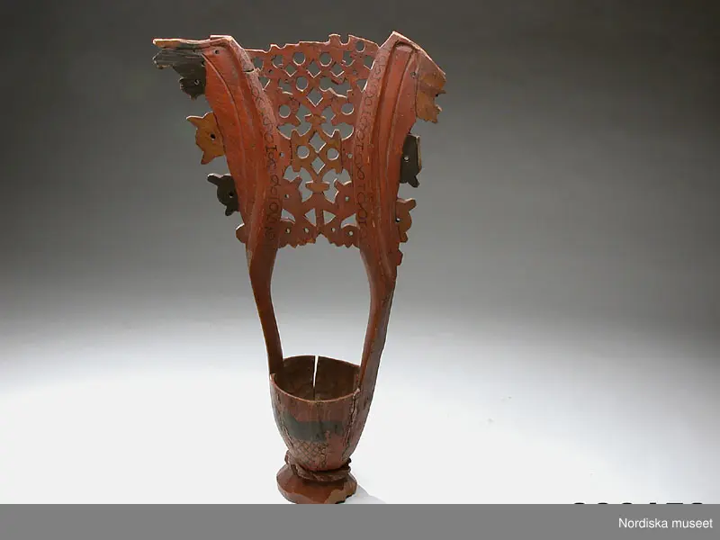 Katalogkort:
Kåsa av gran, rödmålad, omkr. 1590 (Cleve). Med Bielkes och Stures vapen (Hogenskild Bielke och Anna Sture, gifta 1569). Med ornament i svart färg."