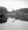 Motiv från Örebro, Svartån och byggnader.
Hamnplatsen Örebro Rederi ABs hamnmagasin, till vänster  i bakgrunden den gamla saluhallen.

15 juli 1939.
