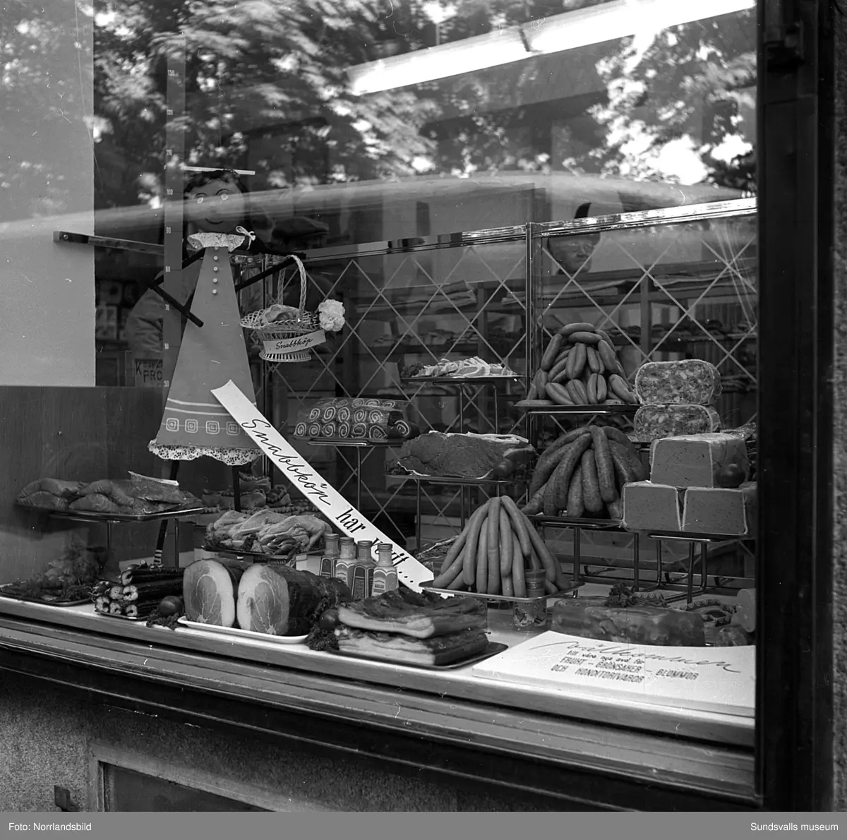 Konsums snabbköp vid Bankgatan har byggts ut 1952 och en kund är sångerskan Alice Babs som inspekterar fruktavdelningen och handlar för fem kronor och femtiosju öre.