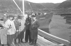 Fem menn på kaia i Hammerfest. Alle har en flaske i hendene 