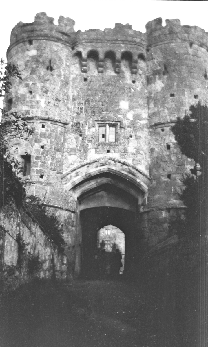 Carisbrooke Castle ved Carisbrooke. Noen personer står i mørket under porten som er hovedinngangen til slottet Carisbrooke.