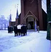 Begravning i Ljusnarsbergs kyrka, män som bär likkistan ut från kyrkan.
Greger, Rällså.