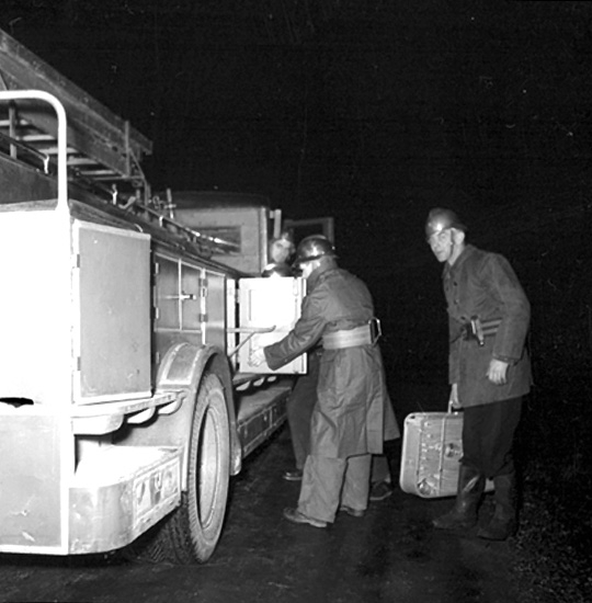 Brandkåren i Ställdalen, brandsläckningsarbete, brandmän.
Brandmannen till höger med väskan i handen är Sven Johansson.