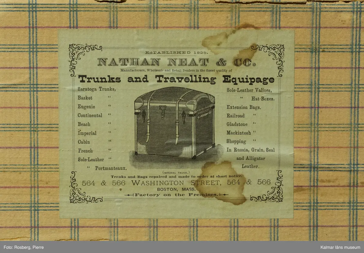 KLM 39675. Koffert, reskoffert, trä, papp, textil, läder, metall. Koffert för förvaring och resor, av trä, klädd med väv, beslag av trä och järn, lås av metall, två spännen och ett handtag av läder på varje gavel. På locket fyra beslag av trä och två på fronten. Insidan är klädd med papp eller tapet med rutigt mönster i rött, grönt och blått på gul botten. 
På lockets insida en fastklistrad tillverkaretikett med rubriken: NATHAN NEAT & CO TRUNKS and Travelling Equipage (för hela texten se foto). Text i svart på höger gavel: M.J. Boston Mass. Spår av gamla resetiketter på höger gavel. Kofferten är brunmålad. Inköpt i Amerika.