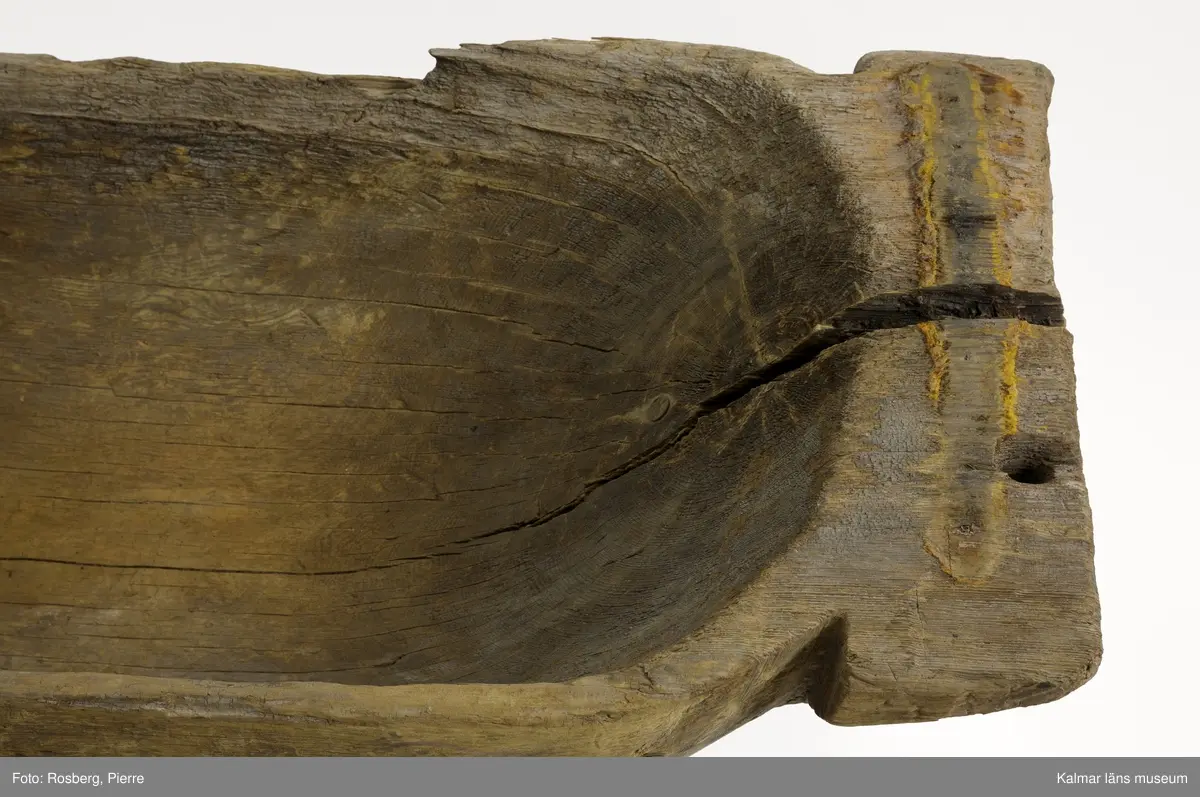 KLM 9352. Båt, stockbåt. Av stor urholkad trädstam, troligen furu. Huggen i ett stycke. Stamrunt tvärsnitt med runt, fallande överhäng. Två tofter och i mitten ett fotstöd. Går ej att uskilja för och akter. Rektangulära och rakt avskurna stävnockar, på den ena ett tamphål.