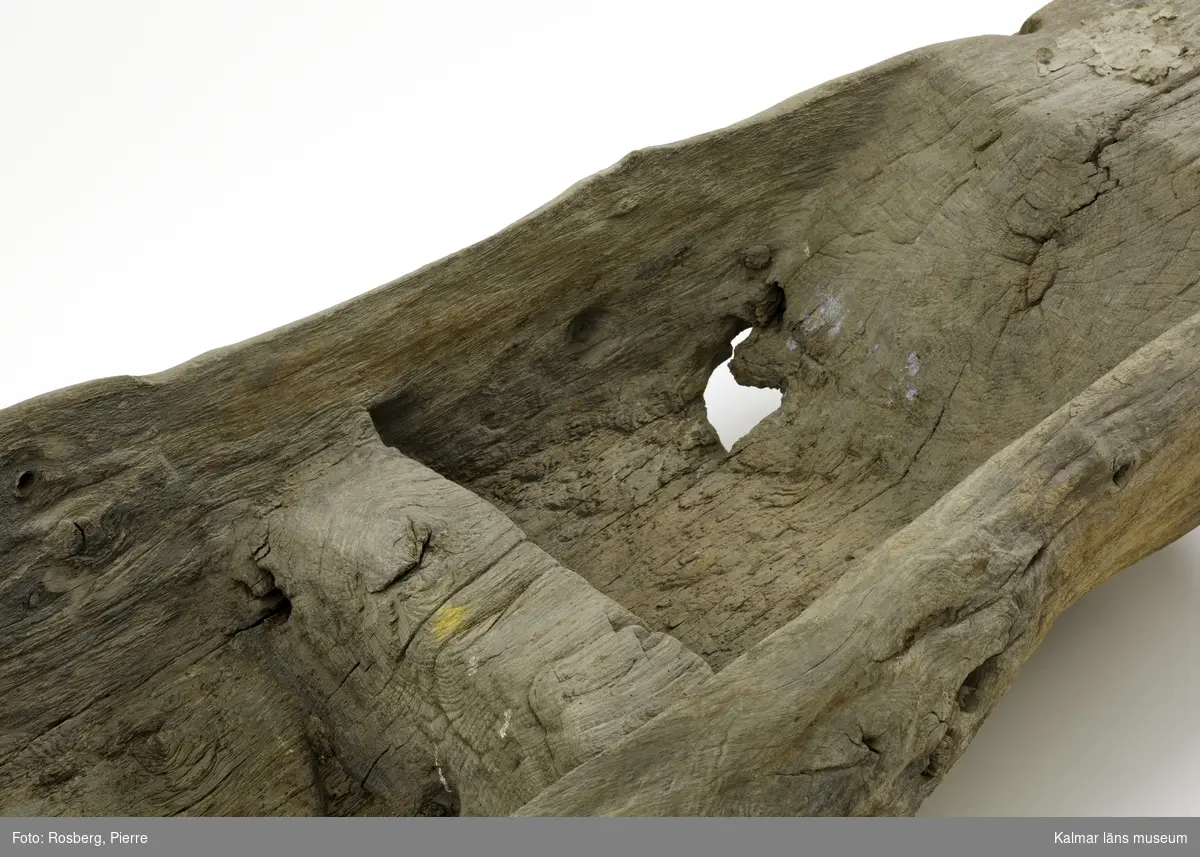 KLM 45113. Båt, stockbåt. Av stor urholkad trädstam, krokig med många knaggar. Huggen i ett stycke. Stamrunt tvärsnitt med runt fallande överhäng. Har tre kraftiga tofter eller skott utsparade i stocken. Går ej att urskilja för respektive akter, eventuellt är den något smalare änden fören. Rektangulära och rakt avskurna stävnockar, på den ena två stycken tamphål. På båtens ena långsida finns fyra stycken relingshål, på den andra sidan ett. På båten fastsatta pappersfragment, tre stycken, med information om båten och dess härkomst, till stor del oläsligt.