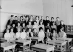 Vasaskolan, klassrumsinteriör, 28 skolbarn med lärarinna fröken Margit Svensson.
Klass 6At, sal 11.