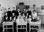 Almby Östra skola, klassrumsinteriör, 19 skolbarn med lärarinna fröken Karin Ohlsson.
Klass 1B, sal 6.