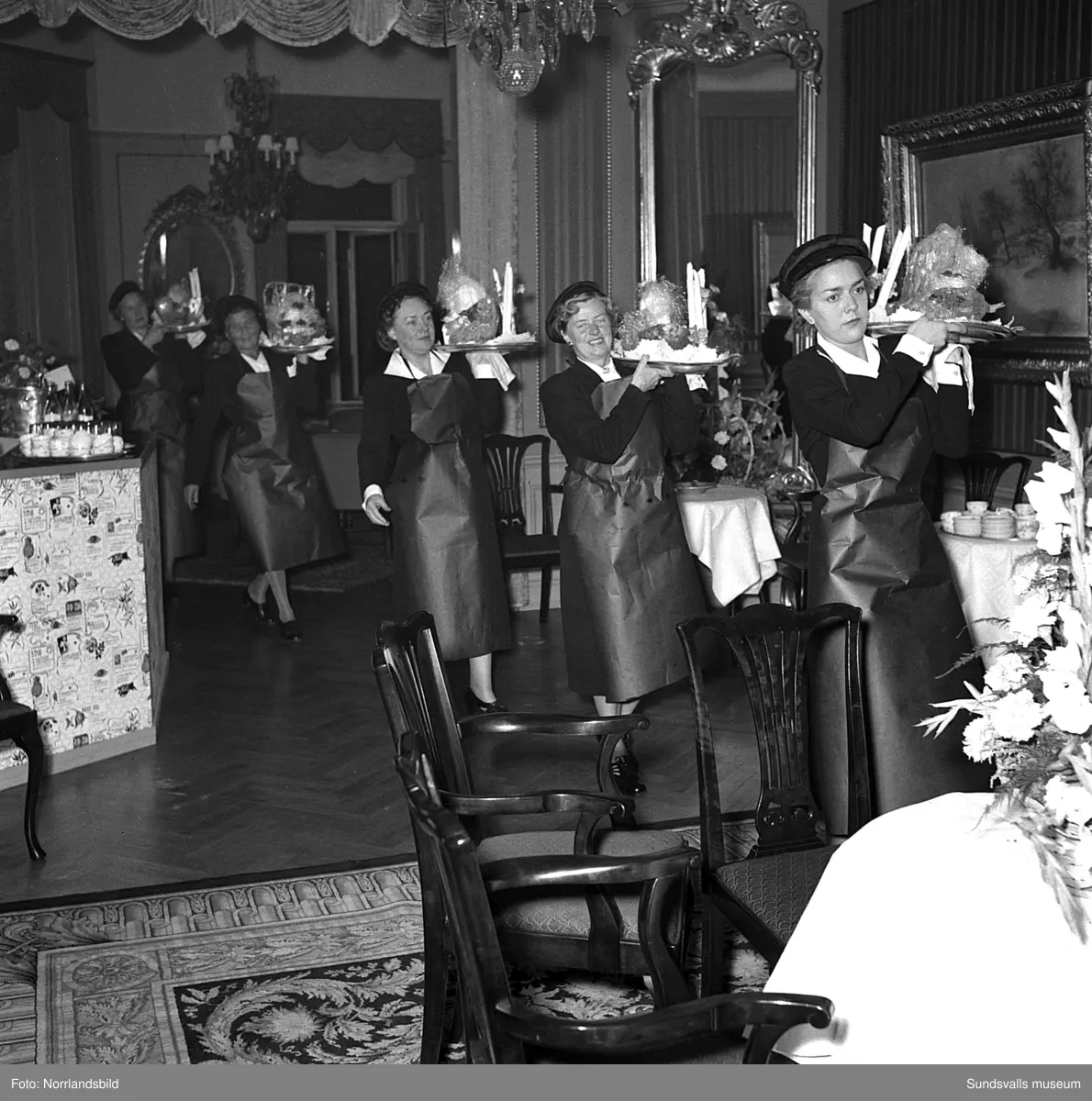 Ett urval av en stor grupp bilder från Lindgrens järnhandels 100-årsjubileumsfest på Knaust. Storstilad entré, mingel, utmärkelser, galamiddag och dans. Underhållning av bland annat en mycket ung Ingeborg Nyberg. På bilderna syns bland annat direktör Fridolf Brunnzell och lagerchefen Carl "Spiken" Lundberg, vilken samma år firade 50 år som anställd vid företaget.