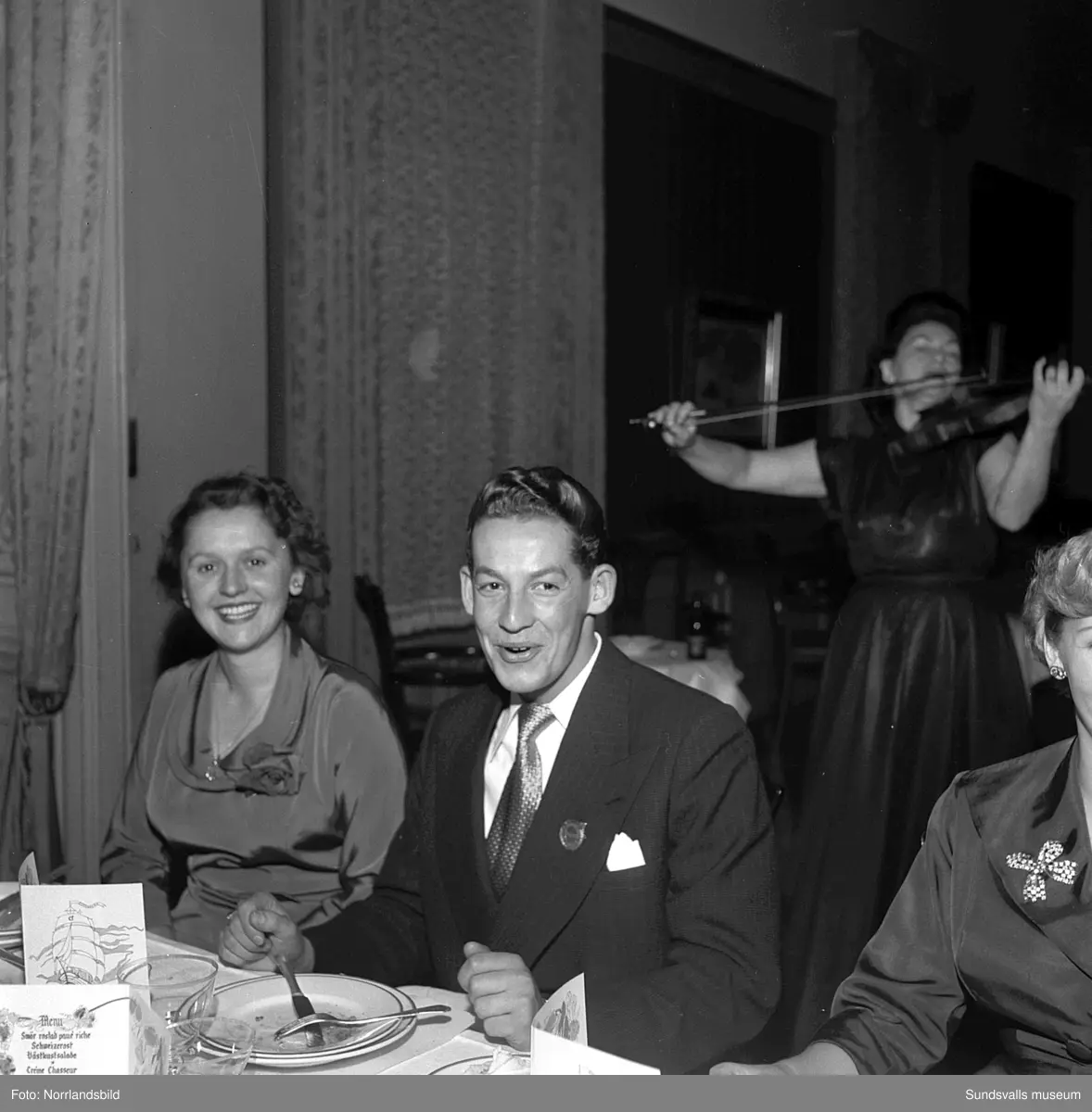 Ett urval av en stor grupp bilder från Lindgrens järnhandels 100-årsjubileumsfest på Knaust. Storstilad entré, mingel, utmärkelser, galamiddag och dans. Underhållning av bland annat en mycket ung Ingeborg Nyberg. På bilderna syns bland annat direktör Fridolf Brunnzell och lagerchefen Carl "Spiken" Lundberg, vilken samma år firade 50 år som anställd vid företaget.