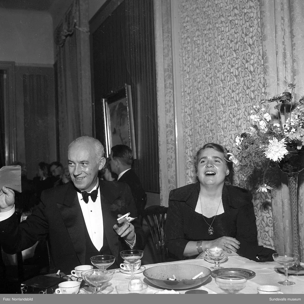 Ett urval av en stor grupp bilder från Lindgrens järnhandels 100-årsjubileumsfest på Knaust. Storstilad entré, mingel, utmärkelser, galamiddag och dans. Underhållning av bland annat en mycket ung Ingeborg Nyberg. På bilderna syns bland annat direktör Fridolf Brunnzell och lagerchefen Carl "Spiken" Lundberg, vilken samma år firade 50 år som anställd vid företaget.