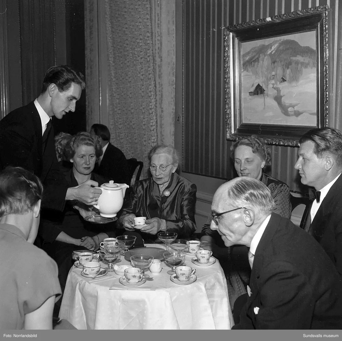 Ett urval av en stor grupp bilder från Lindgrens järnhandels 100-årsjubileumsfest på Knaust. Storstilad entré, mingel, utmärkelser, galamiddag och dans. Underhållning av bland annat en mycket ung Ingeborg Nyberg. På bilderna syns bland annat direktör Fridolf Brunnzell och lagerchefen Carl "Spiken" Lundberg, vilken samma år firade 50 år som anställd vid företaget.