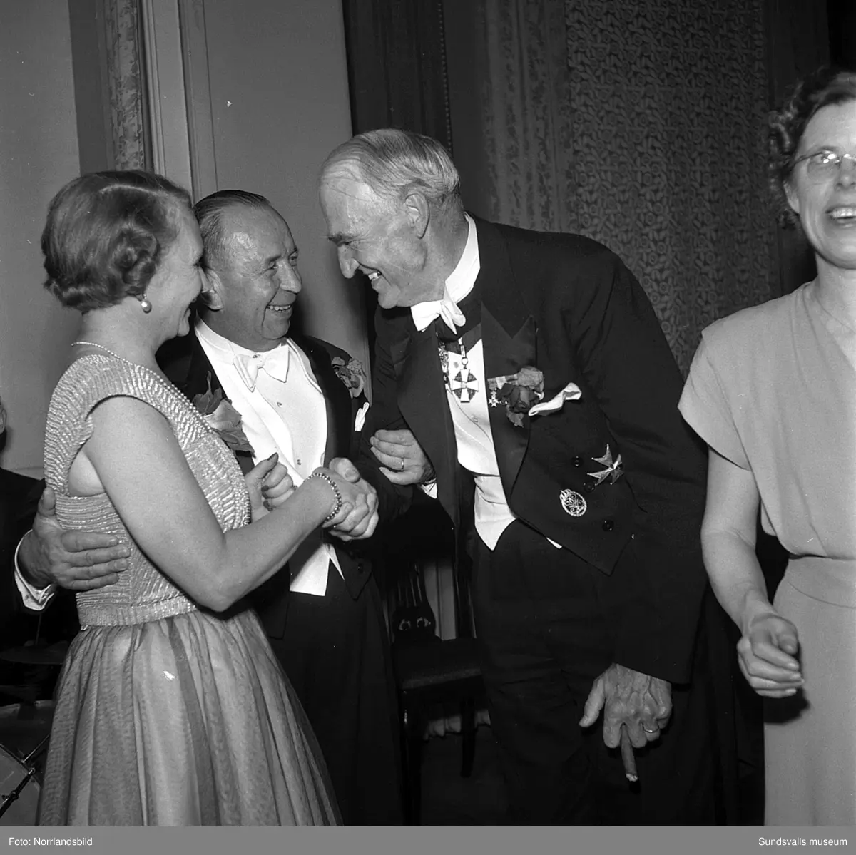 Ett urval av en stor grupp bilder från Lindgrens järnhandels 100-årsjubileumsfest på Knaust. Storstilad entré, mingel, utmärkelser, galamiddag och dans. Underhållning av bland annat en mycket ung Ingeborg Nyberg. På bilderna syns bland annat direktör Fridolf Brunnzell och lagerchefen Carl "Spiken" Lundberg, vilken samma år firade 50 år som anställd vid företaget.