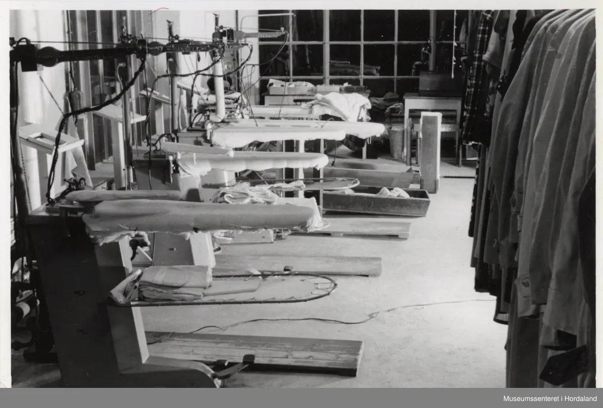 Etterbehandlingsmaskiner for garderobe (stryking/pressing) i lokala til Wilhelm Kahrs Kemisk Renseri & Farveri, Bergen.