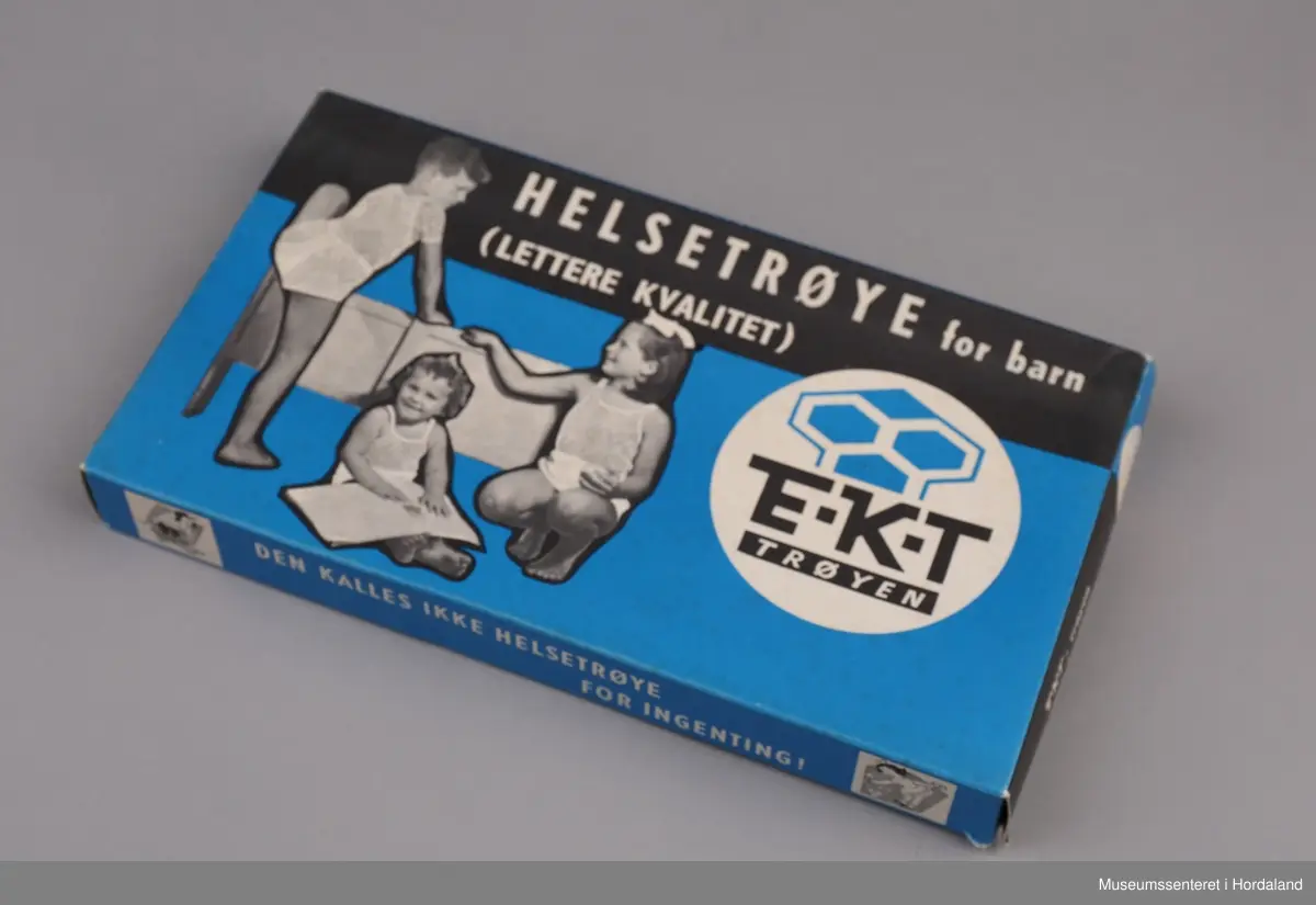 Svart/kvitt foto: tre barn med helsetrøye på blå botn.