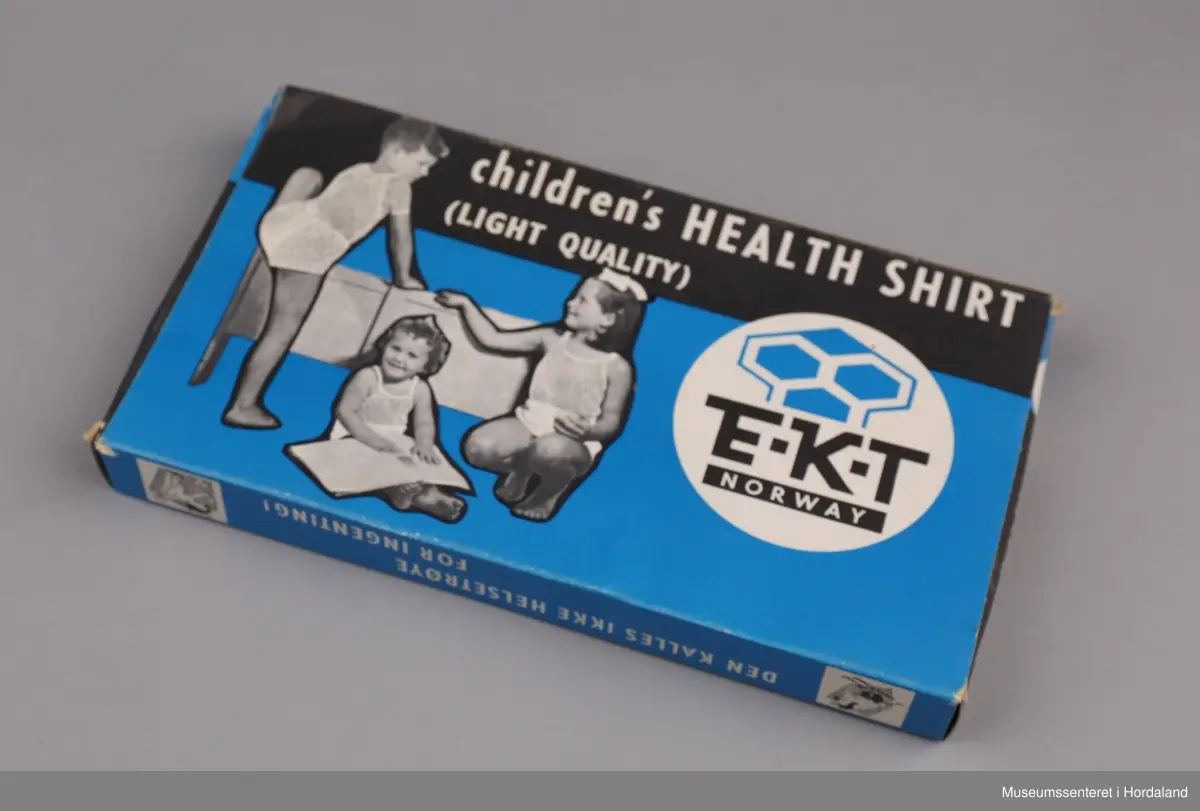 Svart/kvitt foto: tre barn med helsetrøye på blå botn.