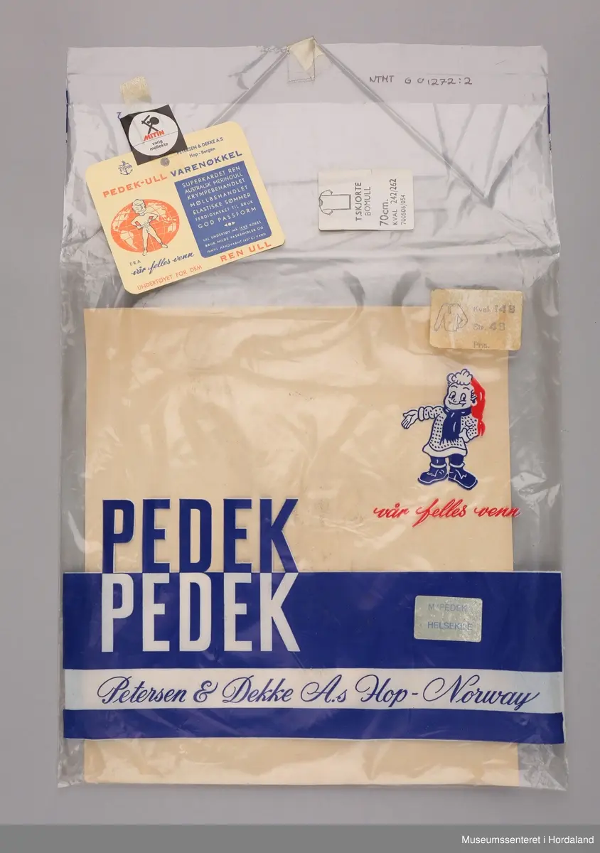 Pedek ulltrøye med lang erm og knepping i stolpe og helsekiler under ermene, pakka i rektangulær plastemballasje.