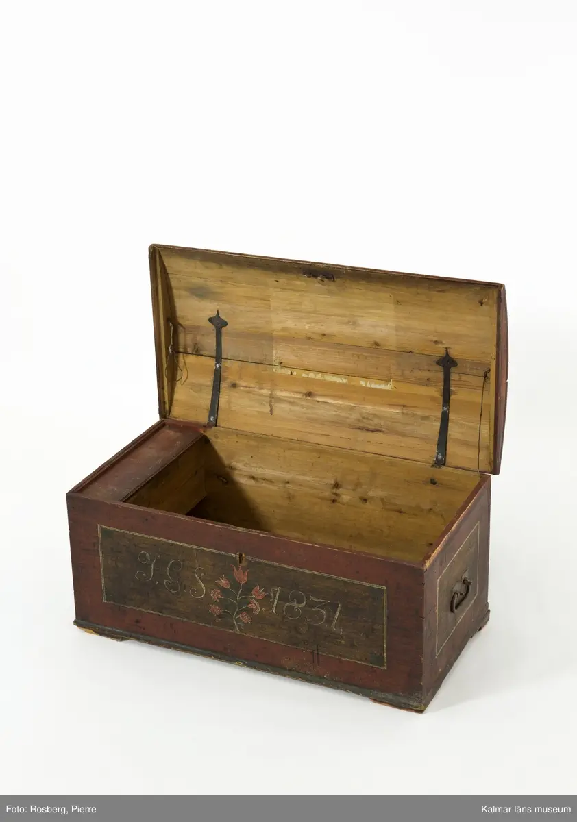KLM 45384. Kista. Furu, järn. Kista med kupat lock och sinkade hörn. Bandgångjärn på insidan av locket och på baksidans utsida. På båda kortsidorna finns bärhandtag av smidesjärn. På fronten syns spår av en oval nyckelskylt, som nu ärborta. Lås saknas. Kistan står på fötter som är kraftigt nedslitna. Kistan är utvändigt bemålad med rödbrunt  ådringsmålat ramverk kring ekådrade fyllningar. Fronten är målad med initialerna J.G.S, årtalet 1831 i vitt, samt en blomsterslinga med sju blommor i rött. Baksidan är  enfärgad i rödbrunt. Inne i kistan finns på vänstra sidan en läddika med med ett lock målat i rödbrunt. I övrigt är kistan omålad invändigt.