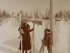 12/3 1918. Två personer med skidor