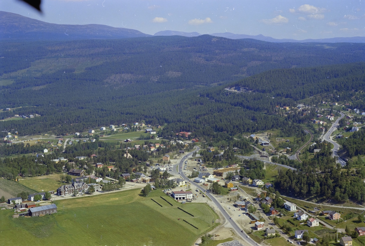 Flyfoto,landskap med fjell,  skog og Dombås sentrum.