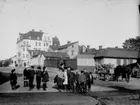 Barngrupp. Bostadshus i bakgrunden. 
Änggatan västerut från Drottninggatan. Fastigheten i fonden Änggatan 15 är byggd 1911.
Bilden är tagen efter år 1911.