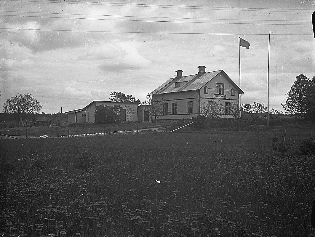 Huset Margretehill i Norberg. Till vänster vedbod och utedass, sedan hönshus. Bakom dem en bod. Huset är fotograferat mot nordväst. Trädgården är inte mycket uppvuxen eller ordnad jämfört med andra bilder. Lars (givaren) säger att huset köptes 1926 men att pensionatrörelsen kom till ganska snart därefter och då sattes skylten "Margretehill" upp. Alltså kan bilden vara tagen i samband med detta.