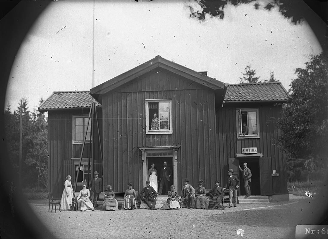 Apotek (Apothek), grupp framför byggnaden.