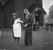 Barndop i Ljusnarsbergs kyrka. Familjegrupp tre personer framför kyrkan.
Strömberg, Ställdalen.