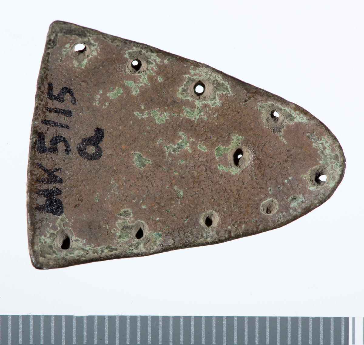Dekor med punslede punkter i linje langs de to lengste kantene. 4 på hver side som møtes i et femte punkt på spissen. I tillegg et punkt på midten av gjenstanden.