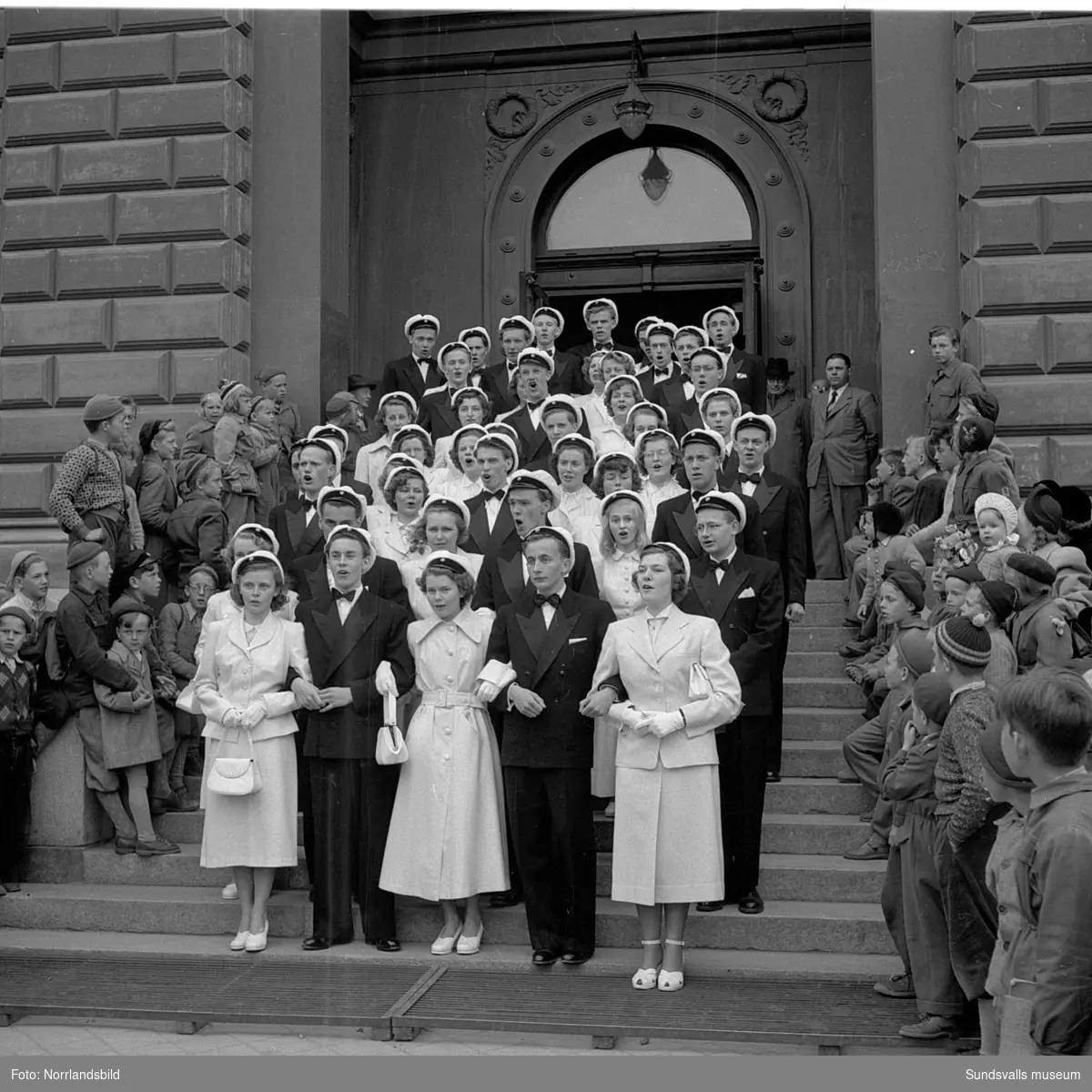 Studentexamen 1951. Studenterna på läroverkets trappa och tågandes utefter Köpmangatan mot stora torget.