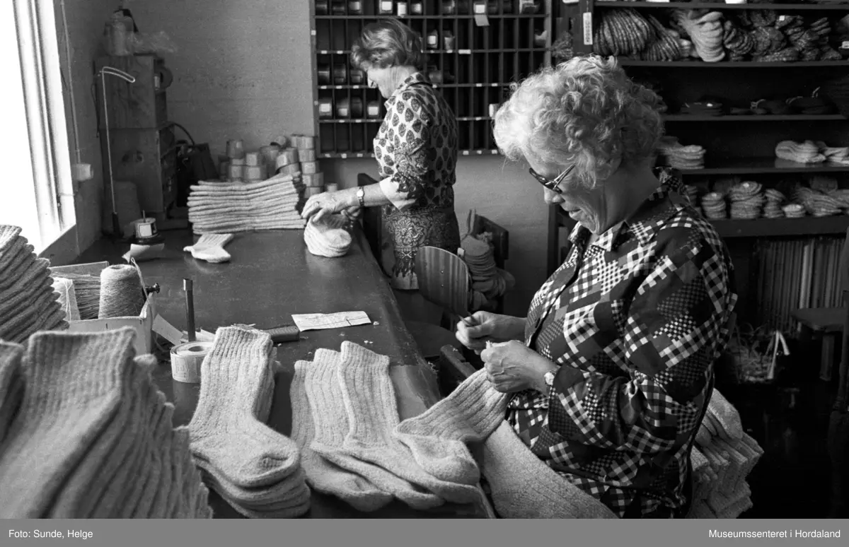 Arbeidsliv ved Salhus Tricotagefabrik i Salhus, Bergen i 1976. Samanlegging av sokkar.

F.v.: NN, Magda Sellevold.