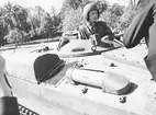 Dåvarande kronprinsen, senare kung Karl XVI Gustaf, sticker upp huvudet ur en lucka till pansarfordon, förmodligen en stridsvagn 103 S, 1960-tal.