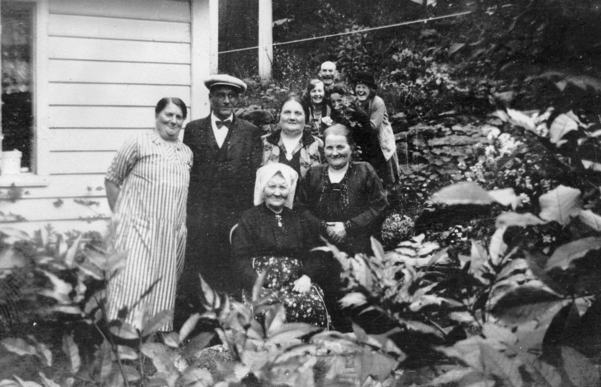Familie i hagen utanfor Skåldalhuset, Salhus. 
Øvst frå venstre: Karen Sofie Monsen Mjelde, Olai Mjelde, Thea Mjelde, Aagot Rasmussen Nordbø, Håkon (...), Kamilla Monsen.
Nedst frå venstre: Kari Mjelde, Laura Mathilda Rasmussen Nordbø.