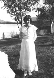 Portrettfotografi av konfirmanten Tora Magerholm i hvit kjol