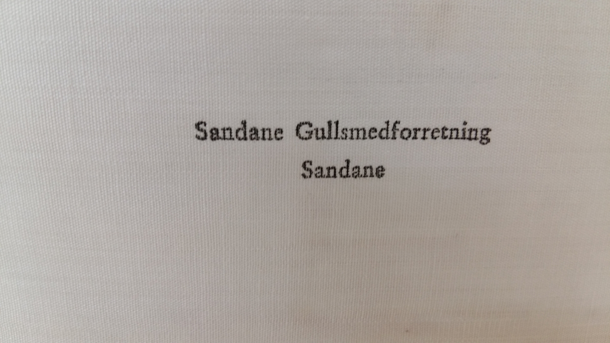 Etui for bestikk. Imitert, svart skinn. Svart øskje med lok hengsla på. Metallukking i gult metall. Fôr i silke i lok. Fôr i flanell i botn. Plass til 12 delar.