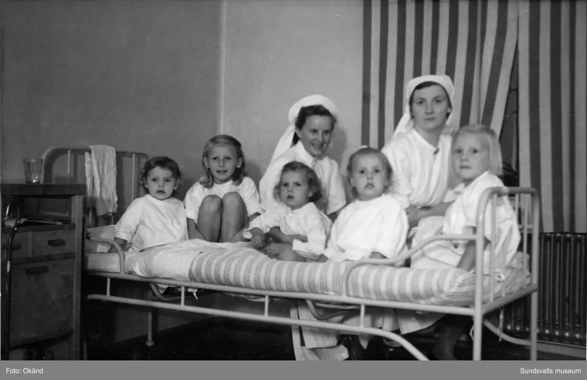 Interiörer, människor och utomhusmiljöer hämtade från Epidemisjukhuset vid Ludvigsbergsvägen (tidigare Epidemivägen) i Alliero. Fotografierna kommer från ett privat album som ägdes av Asta Bergström og Svedlund (f. 1920 d. 2015) som arbetade som sjukvårdsbiträde på Epidemisjukhuset under 20 år från 1942 till 1962. Asta Bergström ses främst på bild 9 och 16 samt flera av de andra bilderna.