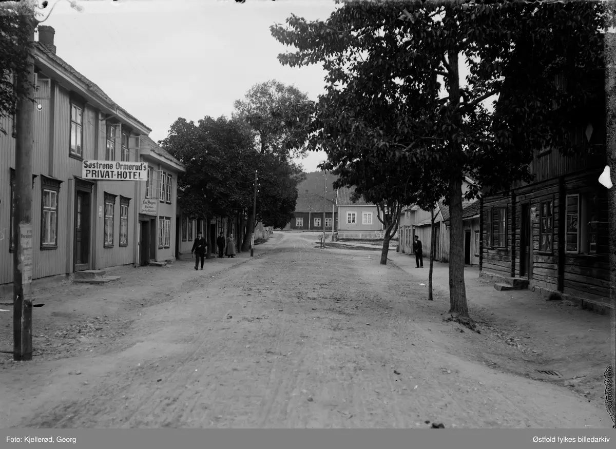 Gateparti i Kongsberg, Skolegata. Søstrene Ormeruds privat-hotell til venstre (skilt). Skilt: Snedker Chr. Bogen.