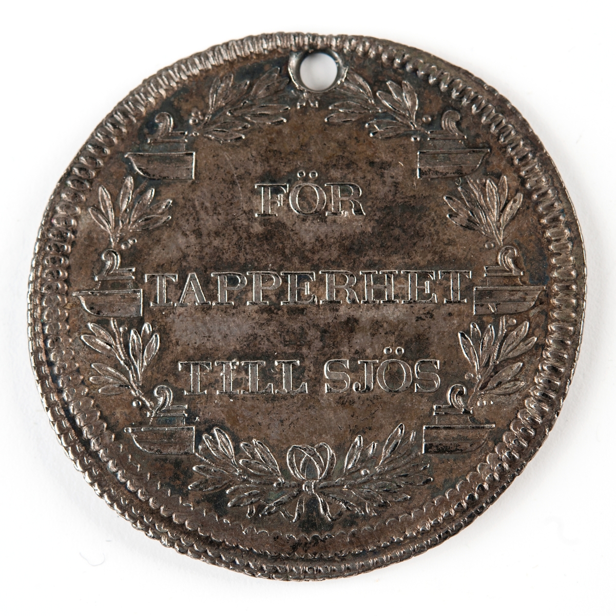 Åtsida: "GUSTAF III. STIFTARE". Konungens bröstbild, höger sida, bar, med långt, utslaget hår. — Nedanför: cmm.
Frånsida: "FÖR TAPPERHET TILL SIÖS" inom en lagerkrans, på hvilken äro fästade sex antika skeppsstäfver (corona navalis).