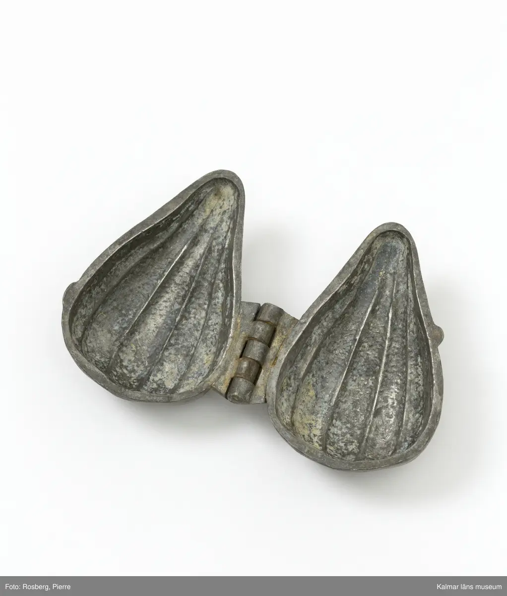 KLM45785:5 Form, av tenn. Form för att gjuta dekorationer i glass. Frukt men oklart vilken. Päron?. På båda sidor stämplad med CC., för företaget Cadot et Cie, Frankrike.