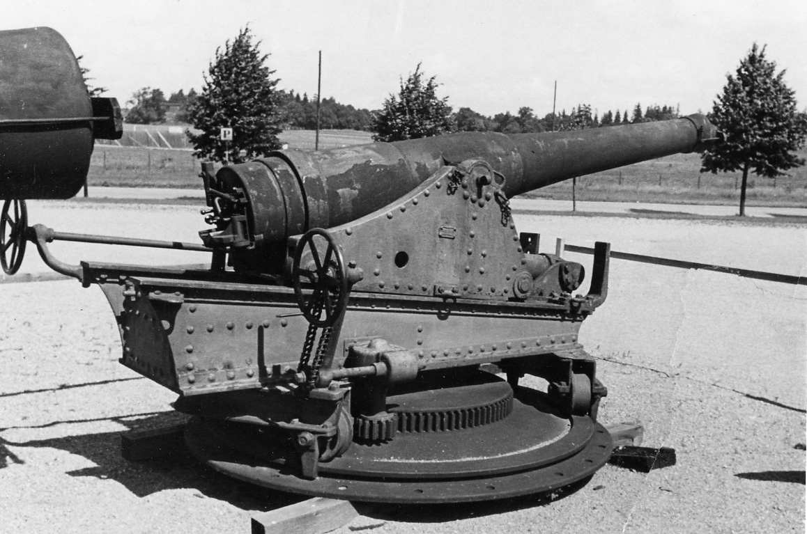 Kanon med kanonrör förstärkt med ett lag av 8 puddelstålband
Troligen m/81

Tillhörande batteriavettage.
Mittelpivotlavettage M/1884 bestående av lavett, kursör och underlag med vandringskema.
Märkt på kusör balkarna: "Fried.Krupp Essen A/G" "No 4"
Kanon och lavett har tillhört aktra batteriet på SKAGUL.