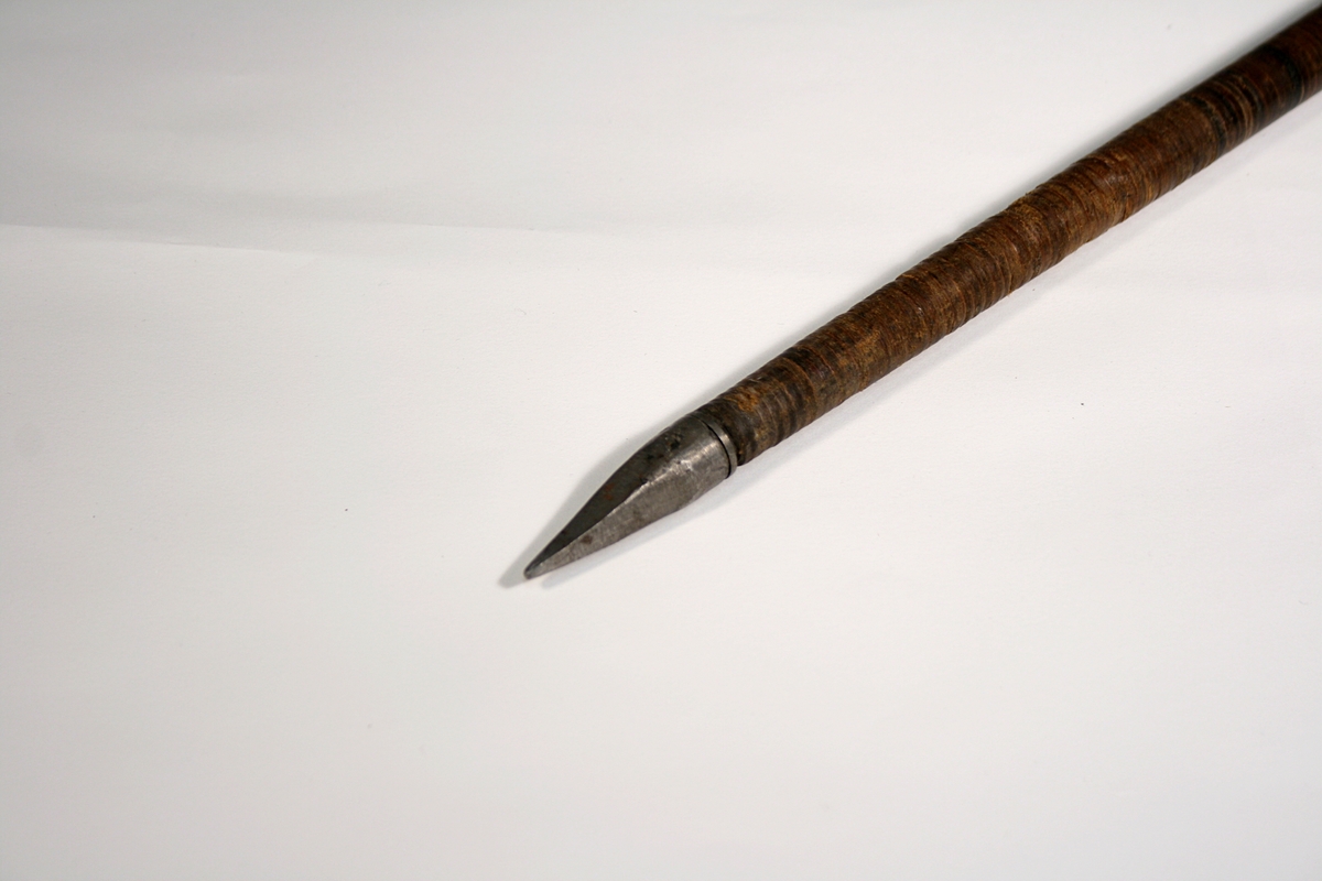 Spaserstokk i tre, surret med lær. Stokken har stålspiss, lærkule som håndtak og lærreim.