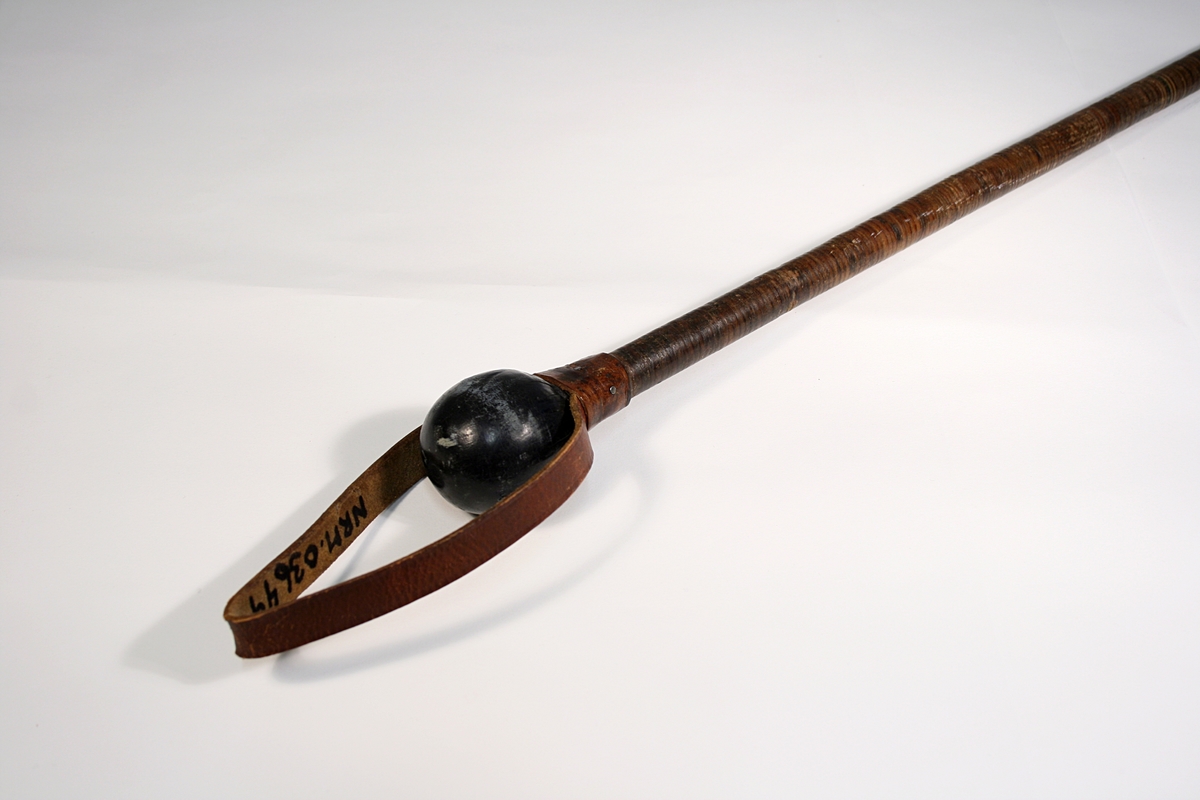 Spaserstokk i tre, surret med lær. Stokken har stålspiss, lærkule som håndtak og lærreim.