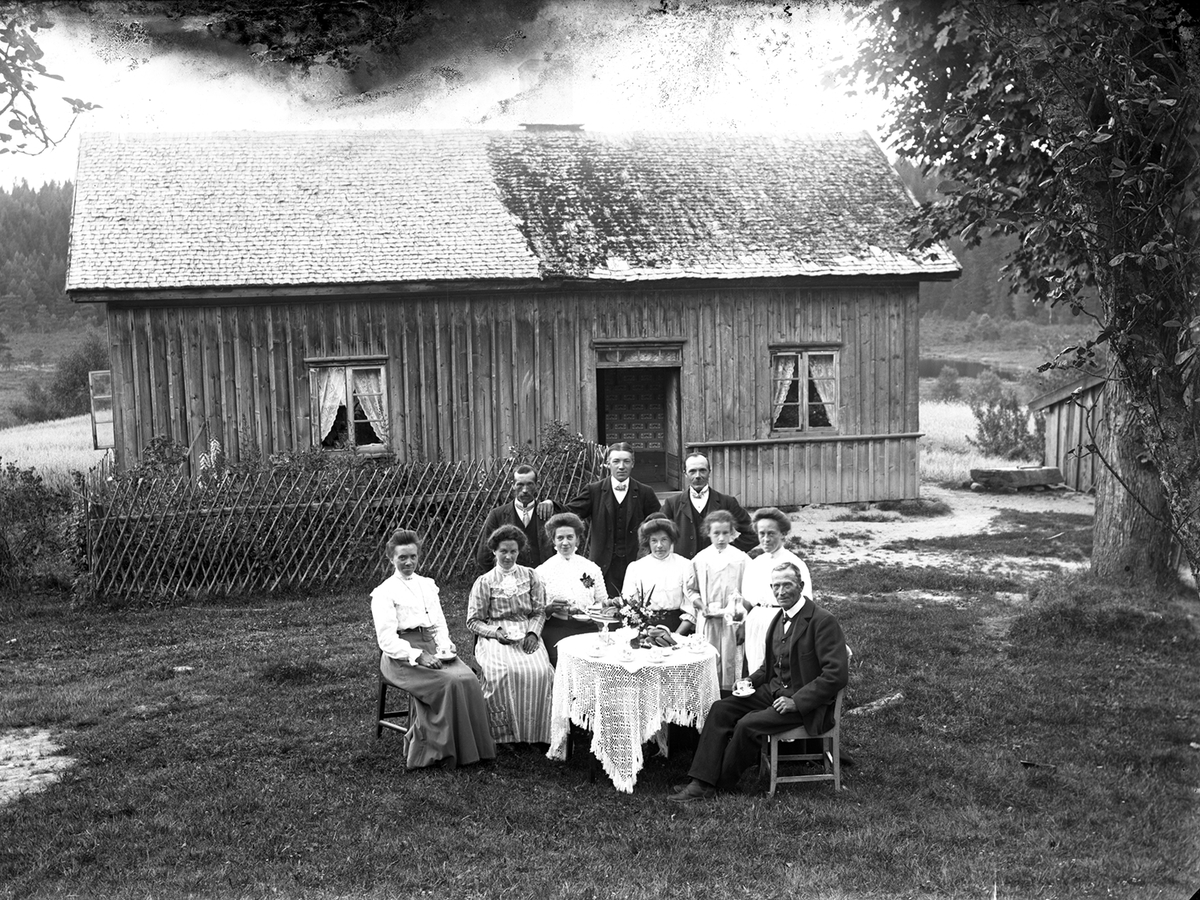 Kalas. Söndagskaffe i trädgården. Familjen Johansson på Spångabacken med vänner. Från vänster: Emma Johansson från Stenshult, Selma Johansson från Spångabacken, Emma Johansson från Spångabacken, Hulda Johanssoon från Stenshult, Judit Carlsson (fosterdotter på Spångabacken), Tilda Johansson från Spångabacken, Emanuel Johansson (far på Spångabacken). Stående från vänster Alfred Johansson från Spångabacken, bröderna Klaes Johansson och Edvard Johansson från Stenshult.Idag är husen rivna och träd planterade på marken. Trädet till höger, en lönn, står fortfarande kvar.