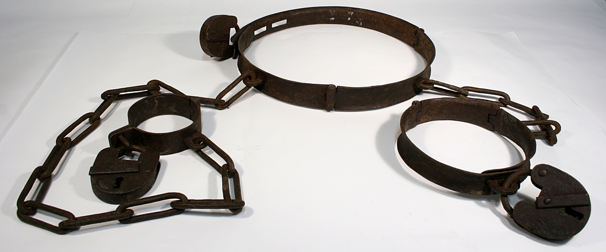 Hals, liv og fotjern festet sammen med lenke. Alle har en hengelås festet.