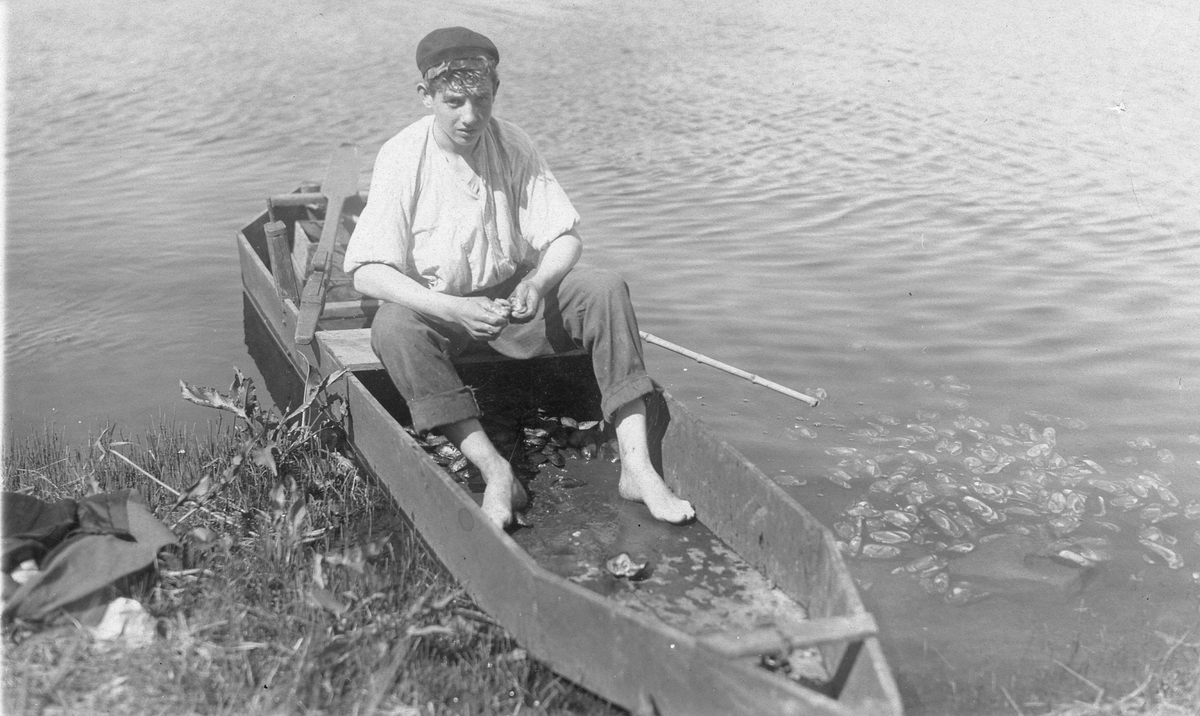 Laholm?. Pärlfiske. Pärlfiske i Lagan?. I vattnet flyter skalen av öppnade musslor, i båten ligger oöppnade.