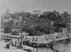 Slussen i Stockholm med de av J.E. Eriksson uppsatta bågljuslamporna på stolpar i förgrunden. Foto från 1890-talet i Stockholms Stadsmuseum.