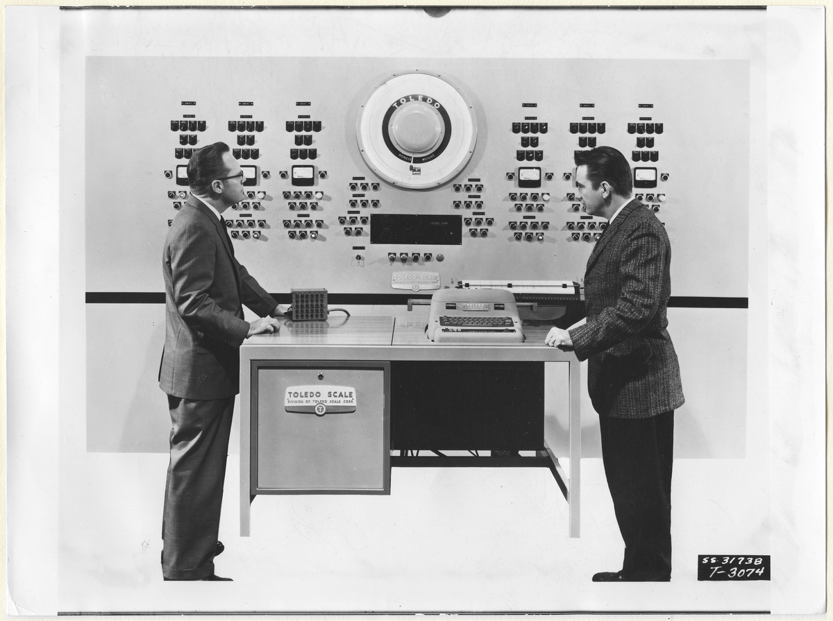 Toledo Scale.
Text från arket där fotografiet är uppfodrat:
"Industriell teknik (Industritidningen Norden)
Elektronisk computer för numerisk styrning av en industriprocess (Toledo)."