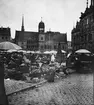 Skioptikonbild med motiv av marknad på torget framför rådhuset i Halle.
Bilden har förvarats i kartong märkt: Resan 1902. Halle 7. Text på bild: 