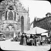 Skioptikonbild med motiv av marknad på torget framför Frauenkirche i Nürnberg.
Bilden har förvarats i kartong märkt: Nürnberg VI. 1901. Text på bild: 