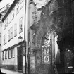 Skioptikonbild med motiv grind av smide längs gata i Bamberg.
Bilden har förvarats i kartong märkt: Resan 1907. Bamberg. 20